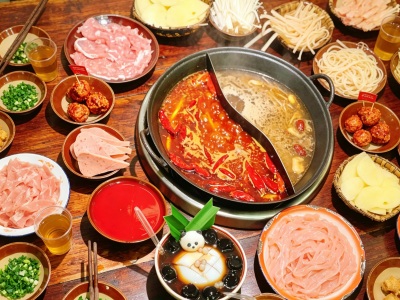 Traditional Sichuan hot pot in Chengdu featuring a split spicy and clear broth with various meats and vegetables