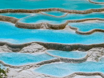 Huanglong Five-Color Pool featuring colorful turquoise ponds and natural travertine terraces in Sichuan China