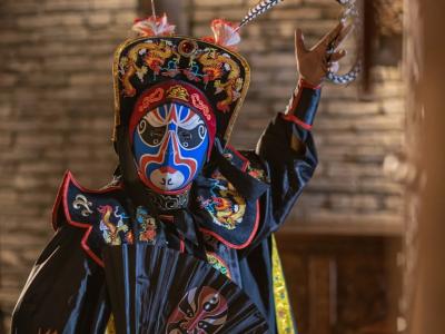 Sichuan Opera performer wearing traditional costume and colorful mask during a face changing show in Chengdu