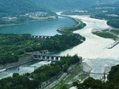 Wide aerial view of Dujiangyan Irrigation System, ancient Min River water conservancy heritage surrounded by green hills