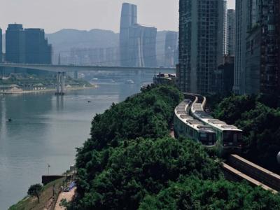 Chongqing city view with a metro train along the hillside, the Yangtze River, bridges and high-rise buildings
