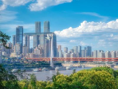 Chongqing skyline with the Yangtze River, modern skyscrapers, bridges, and mountain city scenery under a blue sky