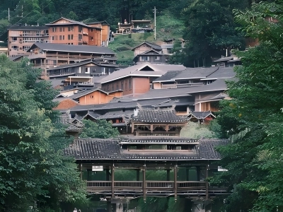 Traditional stilt?houses and wind?rain bridge in Guizhou Miao village, surrounded by green mountains