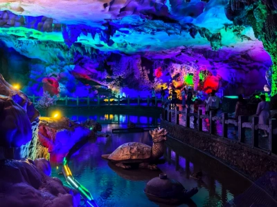 Color?lit Guanyan karst cave with stalactites, underground water and tourists, Guilin