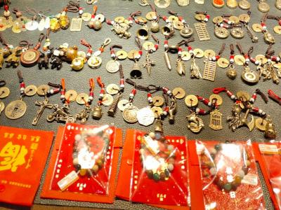 Handmade copper coin pendants symbolizing good fortune are sold at Wulin Night Market