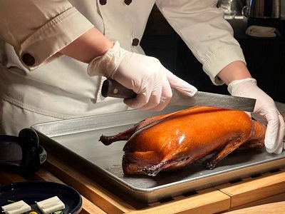 Chef cuts Peking duck in front of you