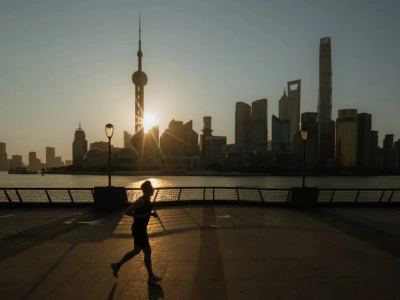 Runner silhouette on Huangpu riverside walkway, Lujiazui skyline sunrise backdrop
