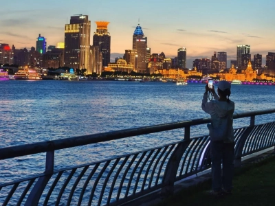 Tourist taking photos of Bund skyline from riverside promenade, Shanghai Tourist taking photos of Bund skyline from riverside promenade, Shanghai