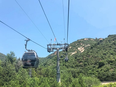 Cable cars traveling over the green mountains near the Badaling Great Wall