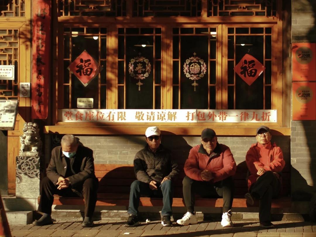 Locals Resting on Hutong Street Bench