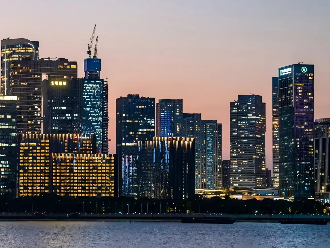Lit high-rise buildings of Qianjiang New Town along Qiantang River at sunset
